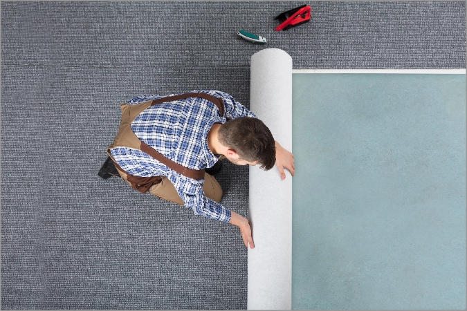 carpet-installation Man roll out carpet for installation | Floors In Motion