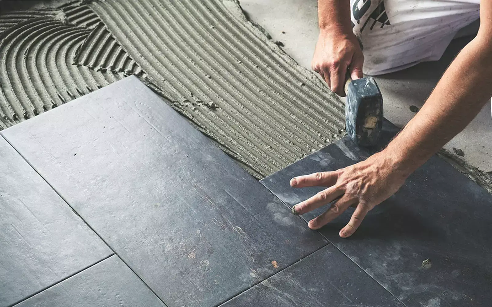 during-tile-installation Worker installing tile | Floors In Motion